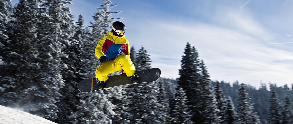Snowboarder im Sprung vor Bergkulisse in Tannheim